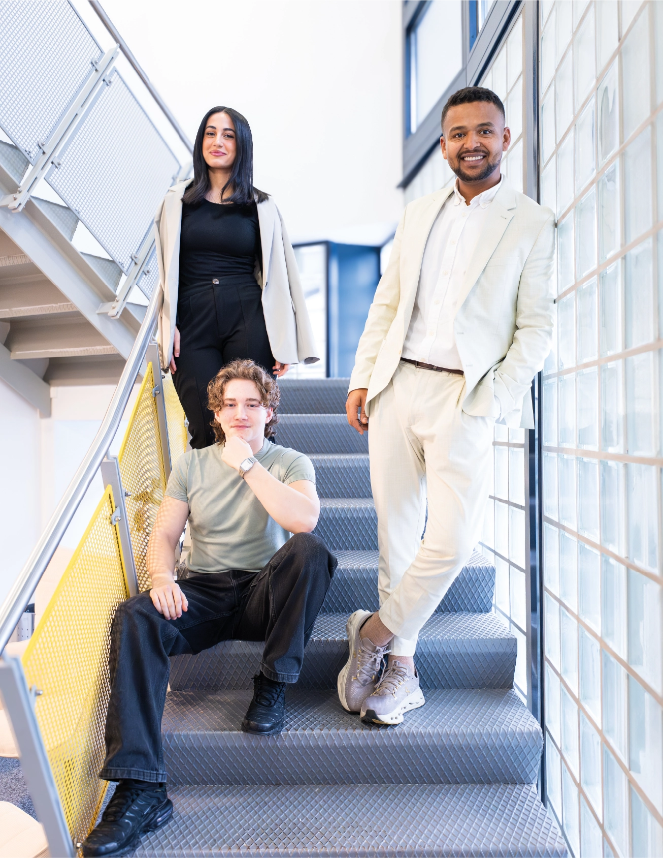Drei Teammitglieder der Barock Academy im hellen Treppenhaus